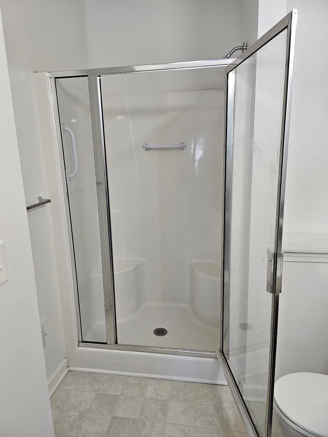Glass shower door after hard-water removal, completely streak-free